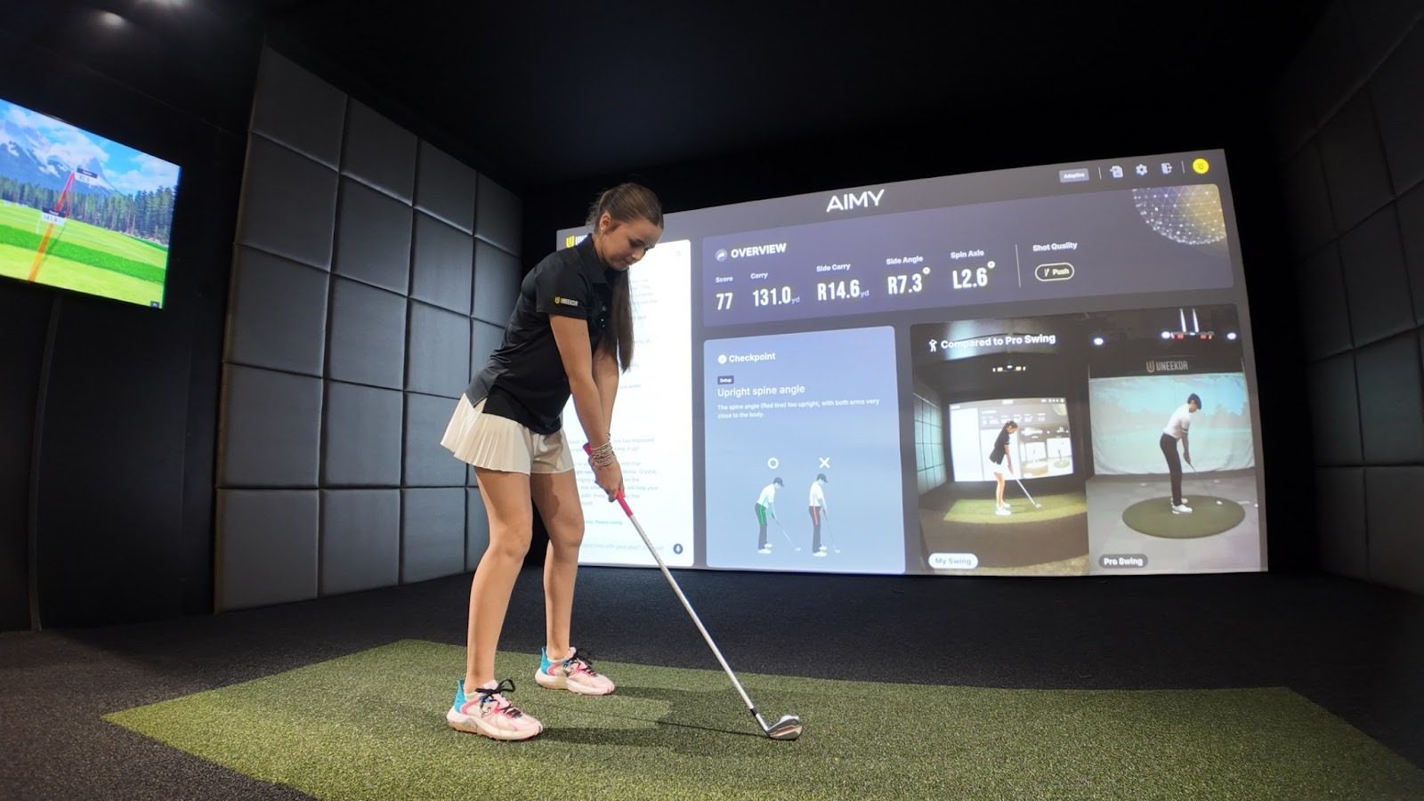 PGA Show 2026 の UNEEKOR ブースで、大画面に AIMY を映してスイングする様子